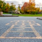 School and schoolyard with hopscotch and playground for elementary students in evening in fall